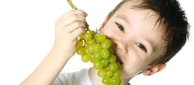 Ein Junge isst Trauben