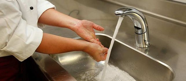 Hände werden über einem Waschbecken gewaschen