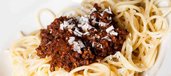 Portion Spaghetti Bolognese mit Parmesan-Flocken
