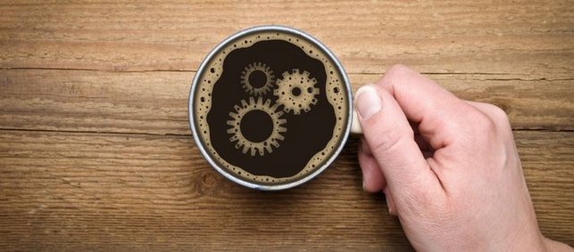 Gesicht aus Zahnrädern in einer Tasse Kaffee