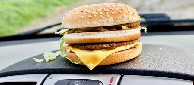 ein Burger liegt auf der Ablage im Auto