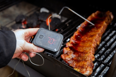 Ein Thermometer steckt im Inneren eines Fleischstücks und zeigt 70 Grad Celsius an.