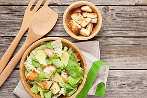 Brotstücke auf Salat und in Holzschale