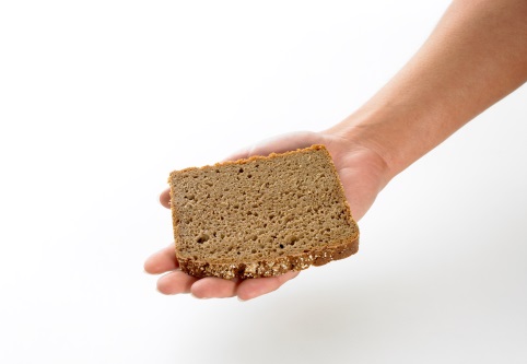 Scheibe Brot auf einer Hand.