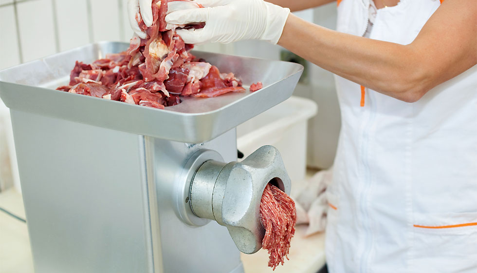 Metzger produziert Hackfleisch mit Fleischwolf