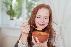 Frau genießt Kürbissuppe