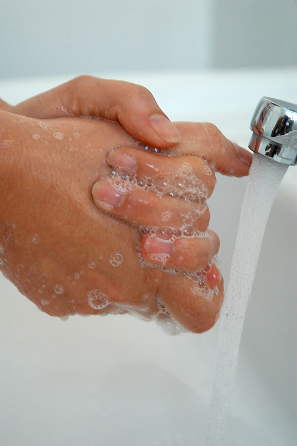 Hände waschen mit Seife unter dem Wasserhahn