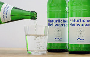 Glasflaschen mit natürlichem Heilwasser und ein Glas