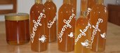 Honigglas und Flaschen mit Bärenfang-Likör auf Holztisch