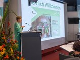 Dr. Margareta Büning-Fesel spricht am Rednerpult neben der Leinwand.
