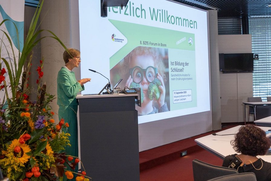 Dr. Margareta Büning-Fesel spricht am Rednerpult neben der Leinwand.