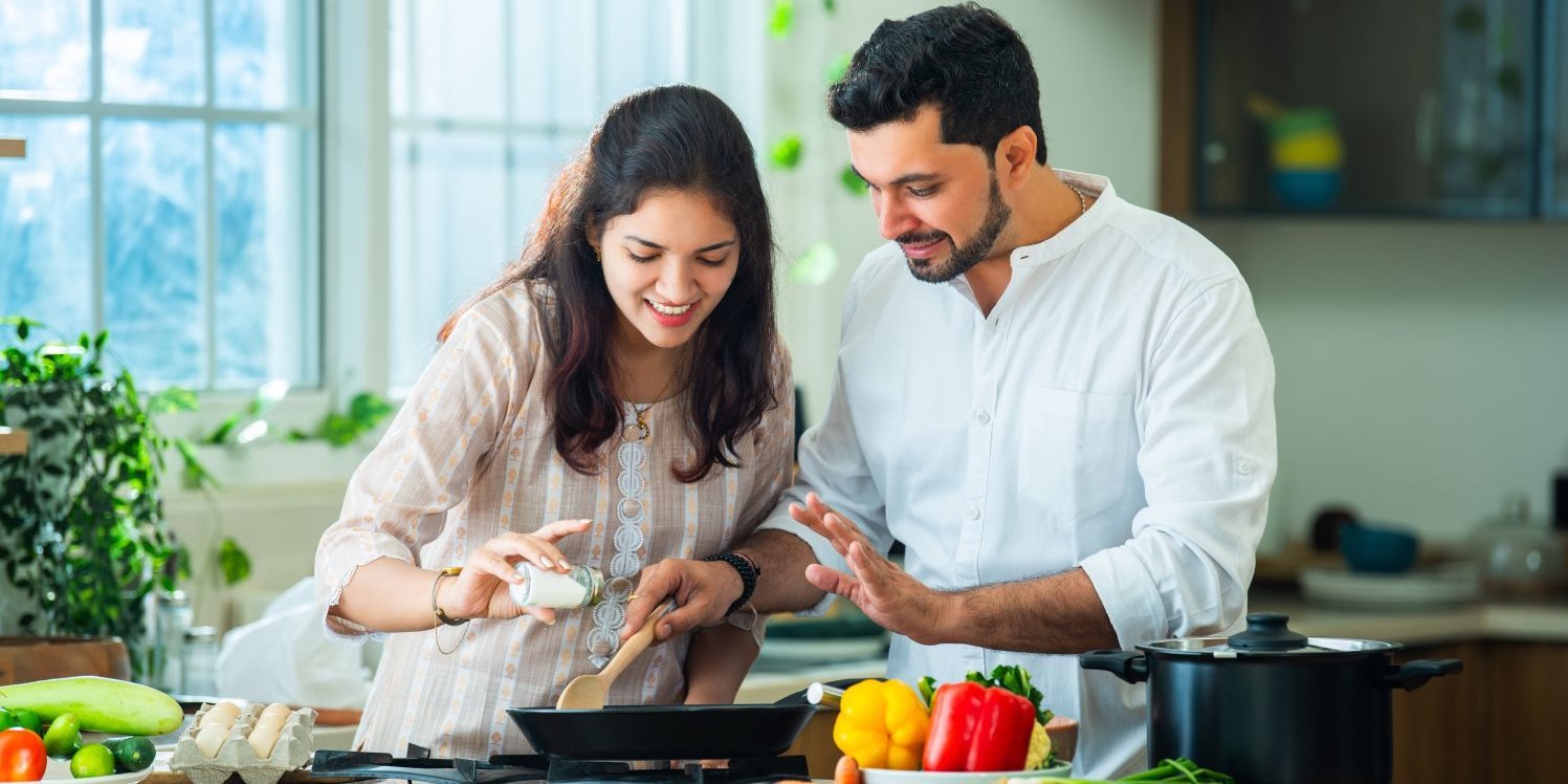 Ein Mann und eine Frau kochen gemeinsam am Herd. . Artikel "Kochen und Aufbewahren" öffnen.