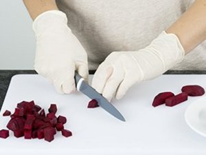eine Person schneidet rote Bete in Würfel.