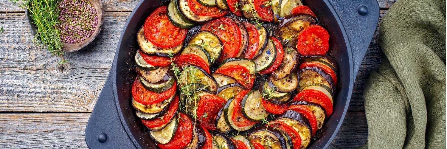 Traditionelle französische Ratatouille im modernen Stil mit Tomaten, Auberginen, Zucchini und Kräuter der Provence, serviert in einer rustikalen gusseisernen Pfanne.