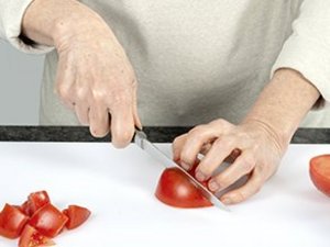 rinr Person schneidet Tomaten.