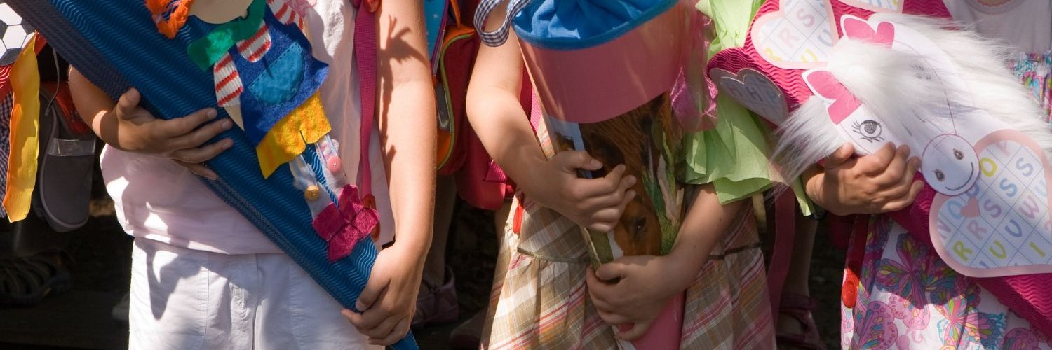 Drei Kinder halten selbstgebastelte Schultüten in den Armen.