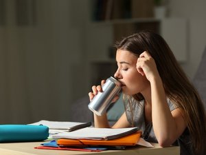Ein Schulkind trinkt aus einer Dose Energy-Drink.