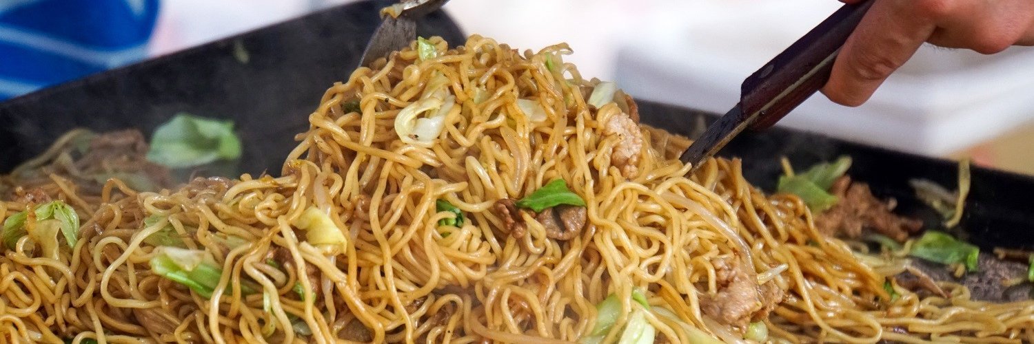 An einem Yatai-Stand in Japan wird das landestypische Nudelgericht „Yakisoba“ frisch zubereitet.