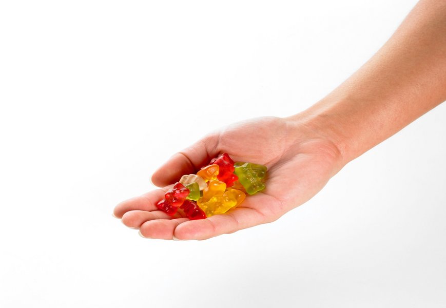 In einer Hand liegt eine Portion Gummibärchen.