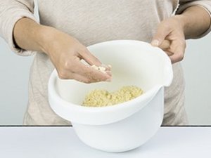 Eine Person macht Streusel in Schüssel.