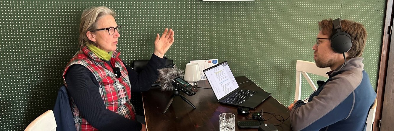 Eine Frau und ein Mann sitzen an einem Tisch und reden.