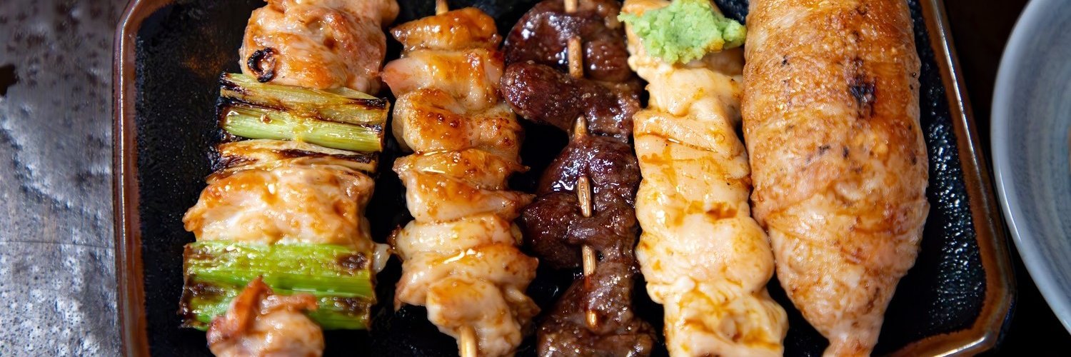 Fünf verschiedene japanische Yakitori-Spieße mit Hähnchen, Fisch, Tofu und Gemüse.