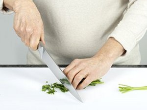 Eine Person gibt Speiseöl in Pfanne.