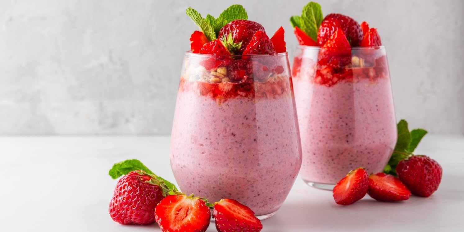 Zwei Gläser mit Erdbeerquark und frischen Erdbeeren stehen auf einer hellen Unterlage.. Artikel "Erdbeeren: Vom Einkauf in die Küche" öffnen.