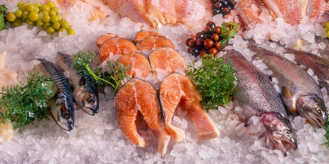 Verschiedene ganze Fische und Fischfilets liegen in einer Theke auf viel Eis.. Artikel "Fisch und Meeresfrüchte" öffnen.