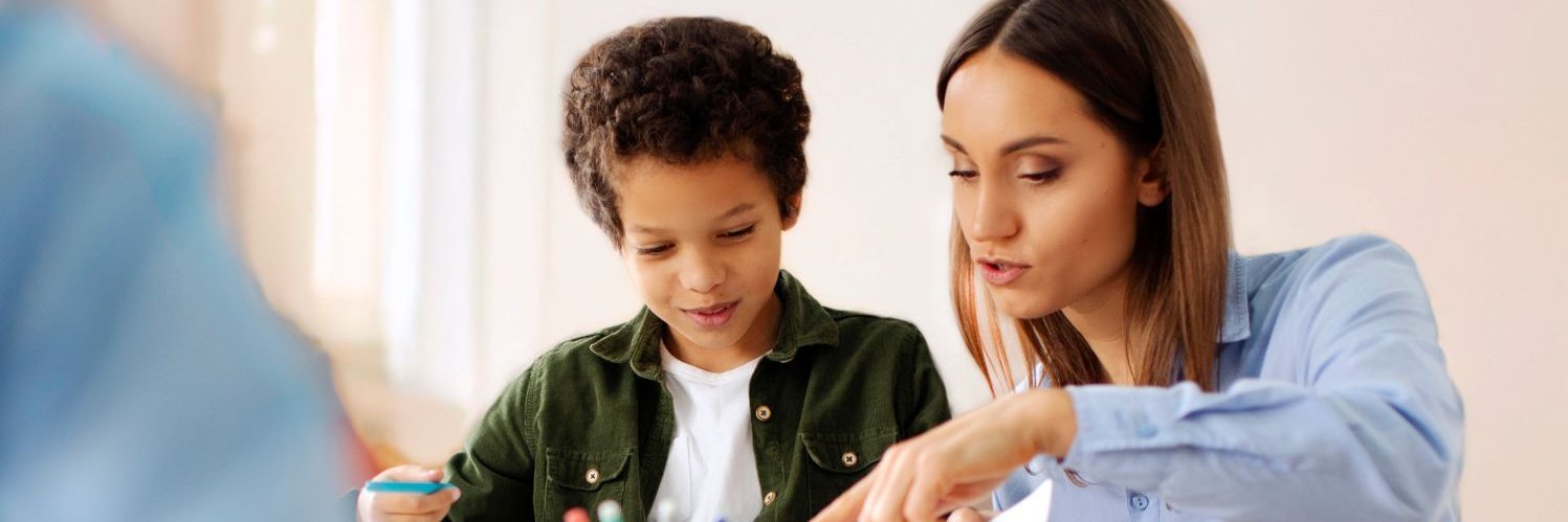Eine Lehrerin hilft einem Schüler.