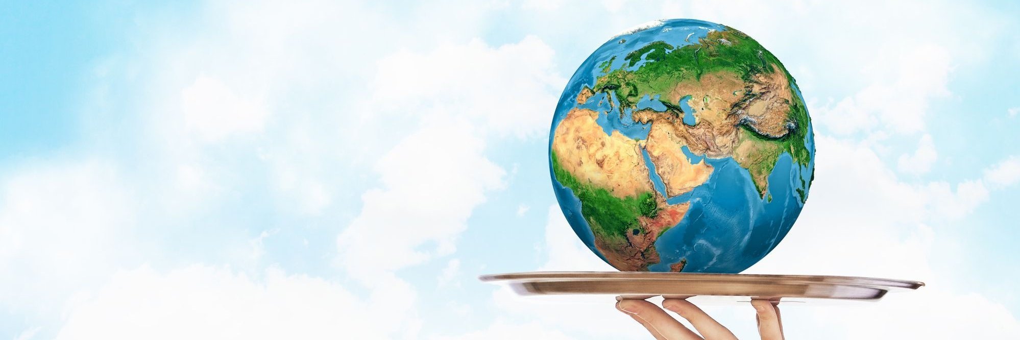 Eine Hand hält ein rundes Metall-Tablett, auf dem eine Weltkugel liegt.