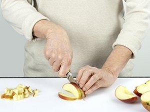 Person schneidet Äpfel in kleine Stücke.