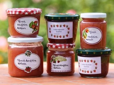 Sechs beschriftete Gläser mit unterschiedlichen selbst gekochten Marmeladen.