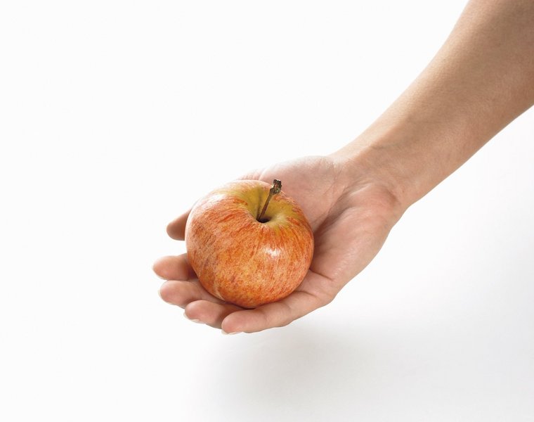 Eine Hand hält einen Apfel.