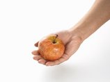 Eine Hand hält einen Apfel.