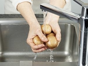 Eine Person wäscht Pilze.