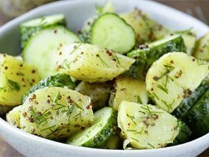 Kartoffelsalat mit Salatgurke in einer Schüssel.