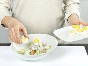 eine Person richtet den Salat schön an.