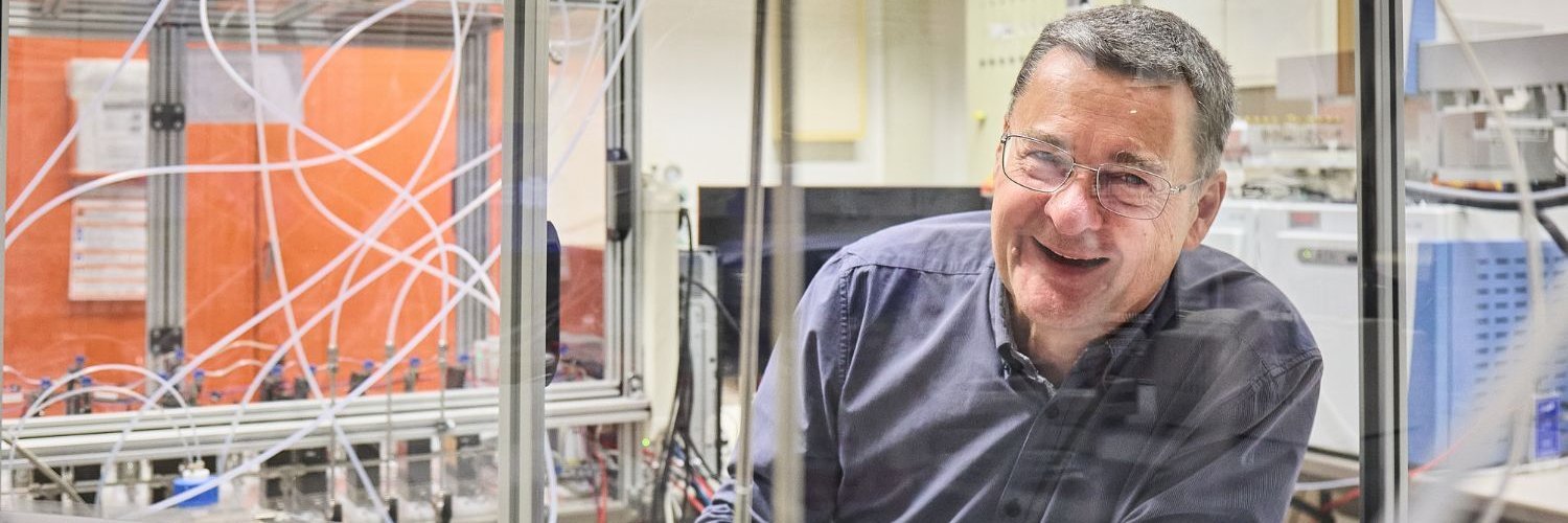 Professor Andreas Schütze steht in seinem Labor und lächelt in die Kamera. 