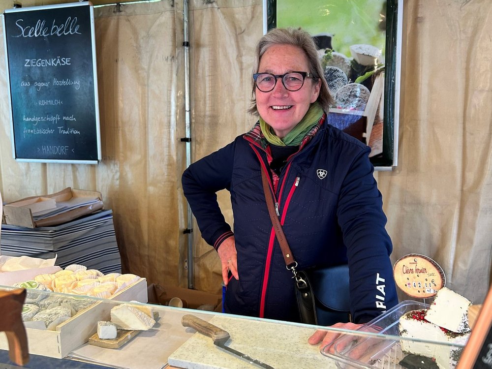 Eine Frau steht in einem Verkaufswagen mit Käse.