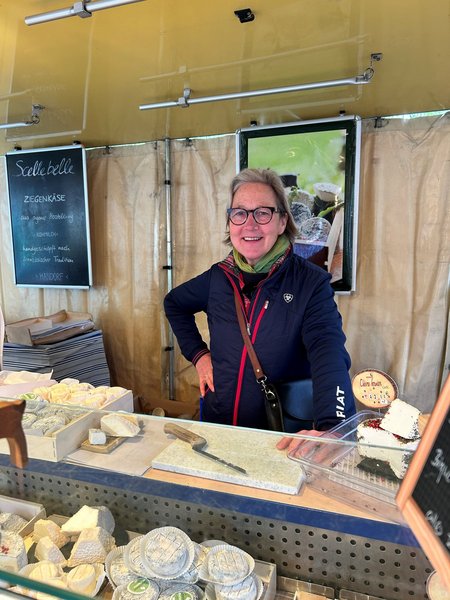 Eine Frau steht in einem Verkaufswagen mit Käse.