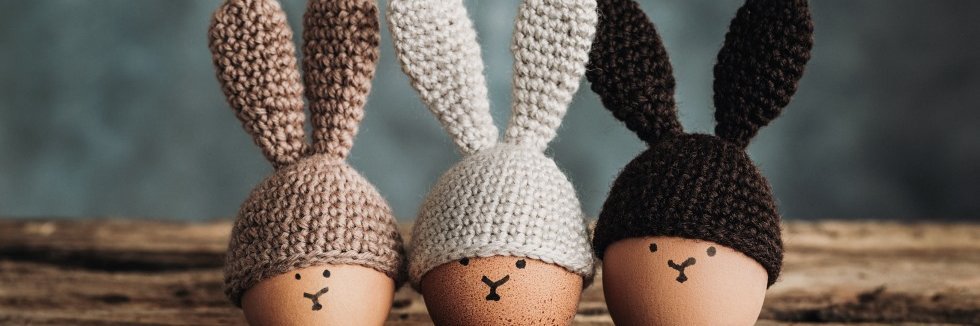 Eier mit Hasengesichtern und Hasenohrenmütze.
