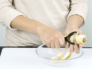 Eine Person schält Pastinake.