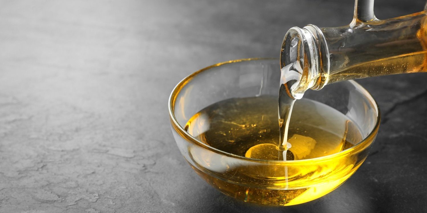 Aus einer Rapsölflasche wird goldgelbes Rapsöl in eine Glasschüssel gegossen.. Artikel "Rapsöl: Vom Einkauf in die Küche" öffnen.