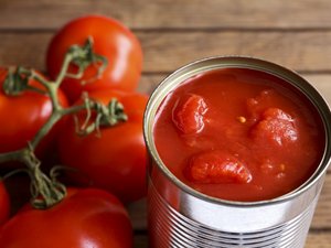 Es ist eine geöffnete Dose mit geschälten Tomaten abgebildet.