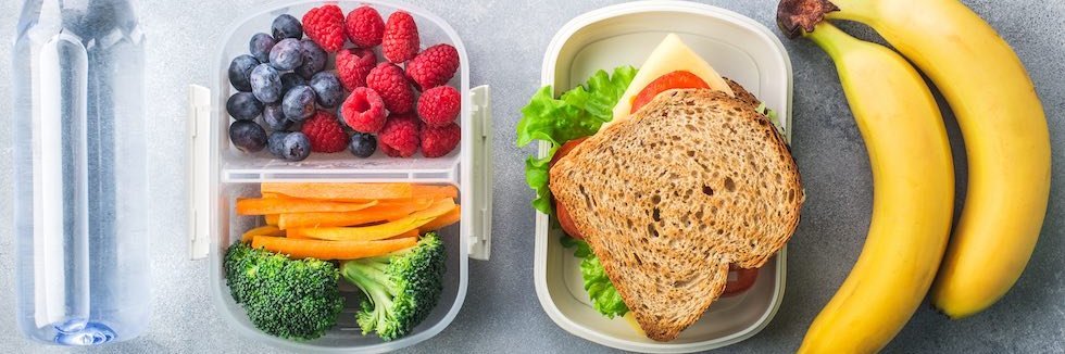 Ausgewogenes Pausenfrühstück mit Wasser, Obst und Gemüse.