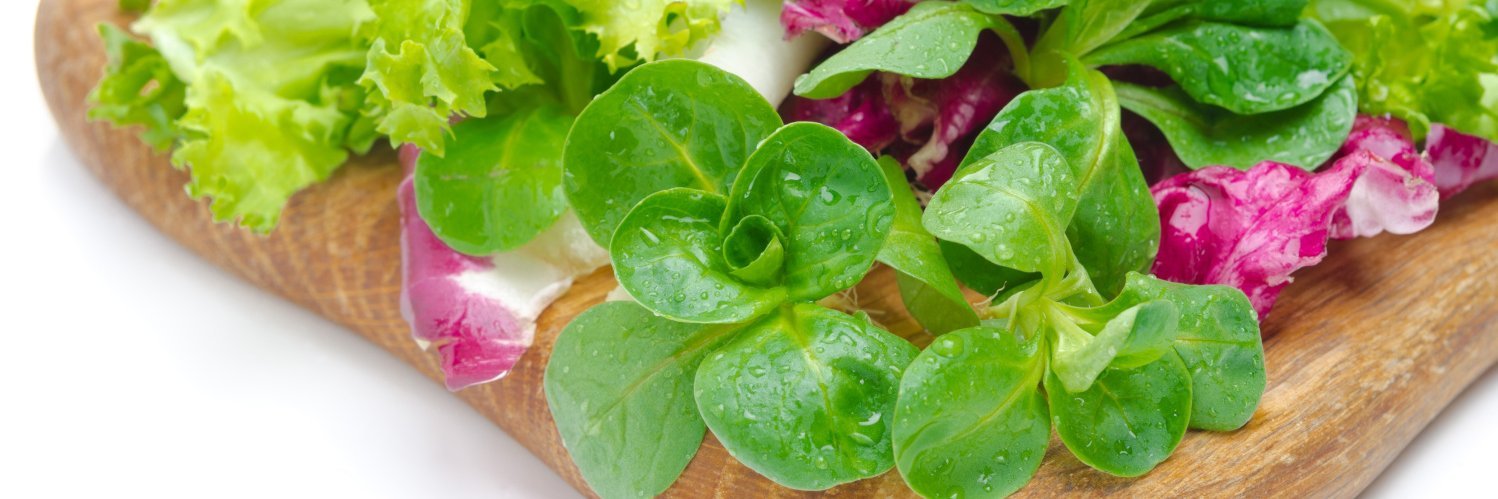 Bunte Salatmischung liegt auf einem Holzbrett.