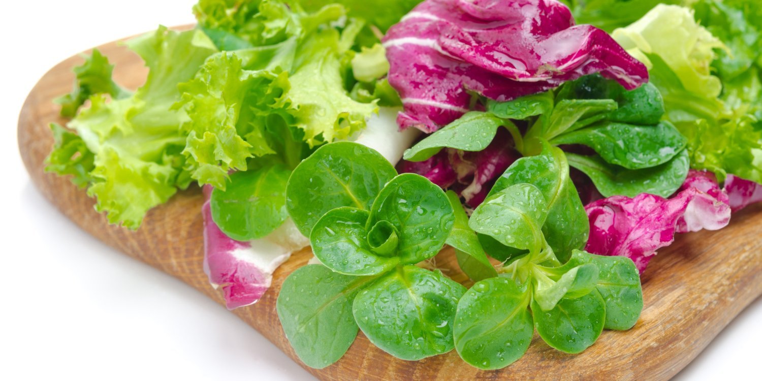 Bunte Salatmischung liegt auf einem Holzbrett.. Artikel "Salate" öffnen.