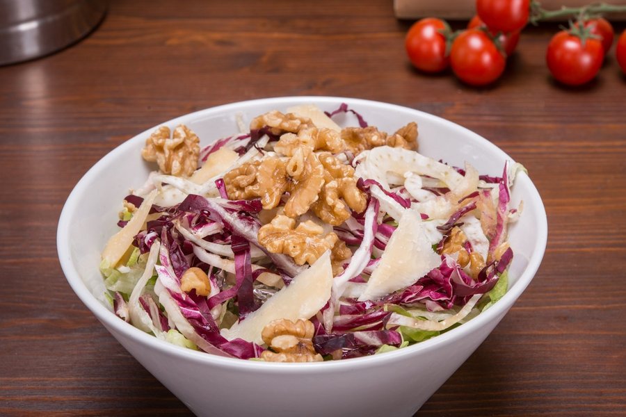 Weiße Schüssel mit Fenchelsalat, Walnüssen und Parmesan.