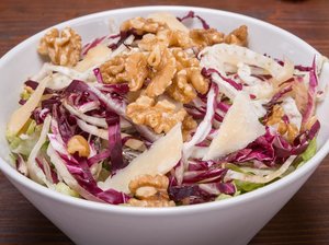 Weiße Schüssel mit Fenchelsalat, Walnüssen und Parmesan.
